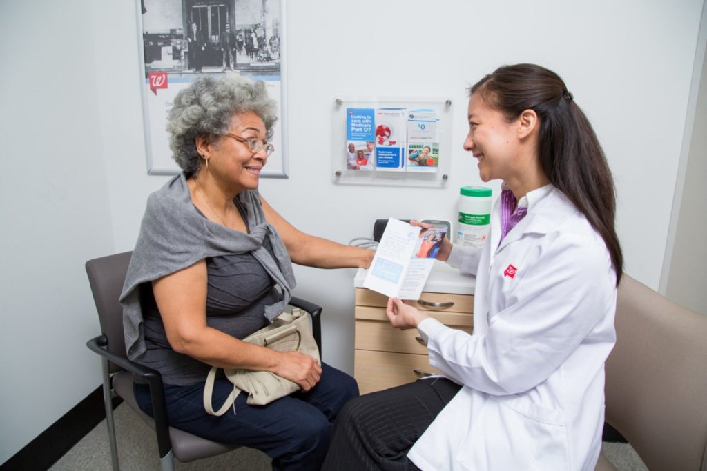 Pharmacy staff member with patient